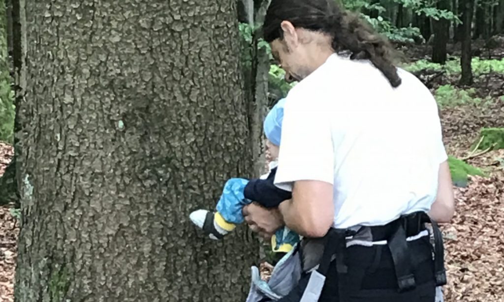 Papa hält Baby am Baum ab